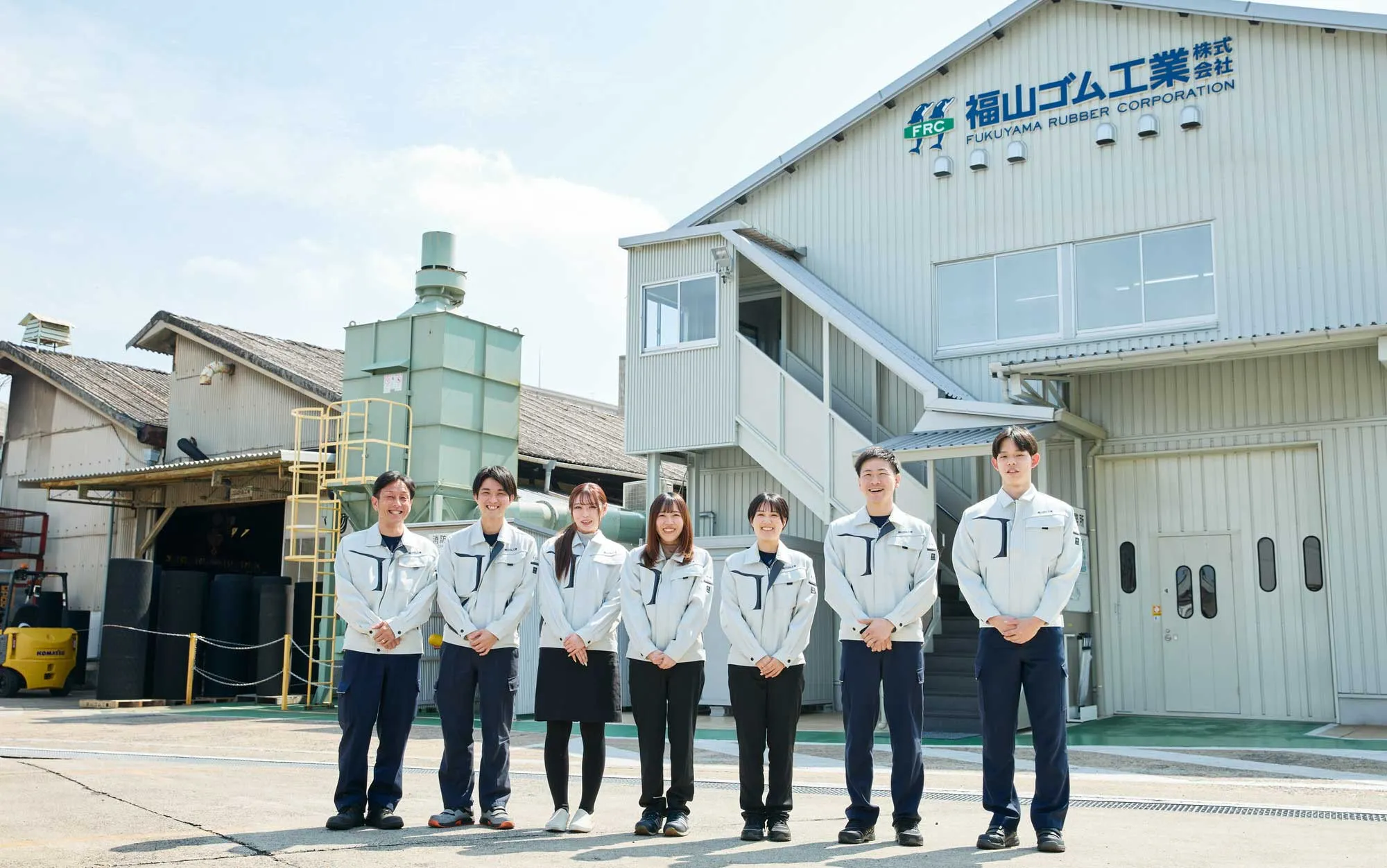 工場前で社員さん達が笑顔で並んでいる様子